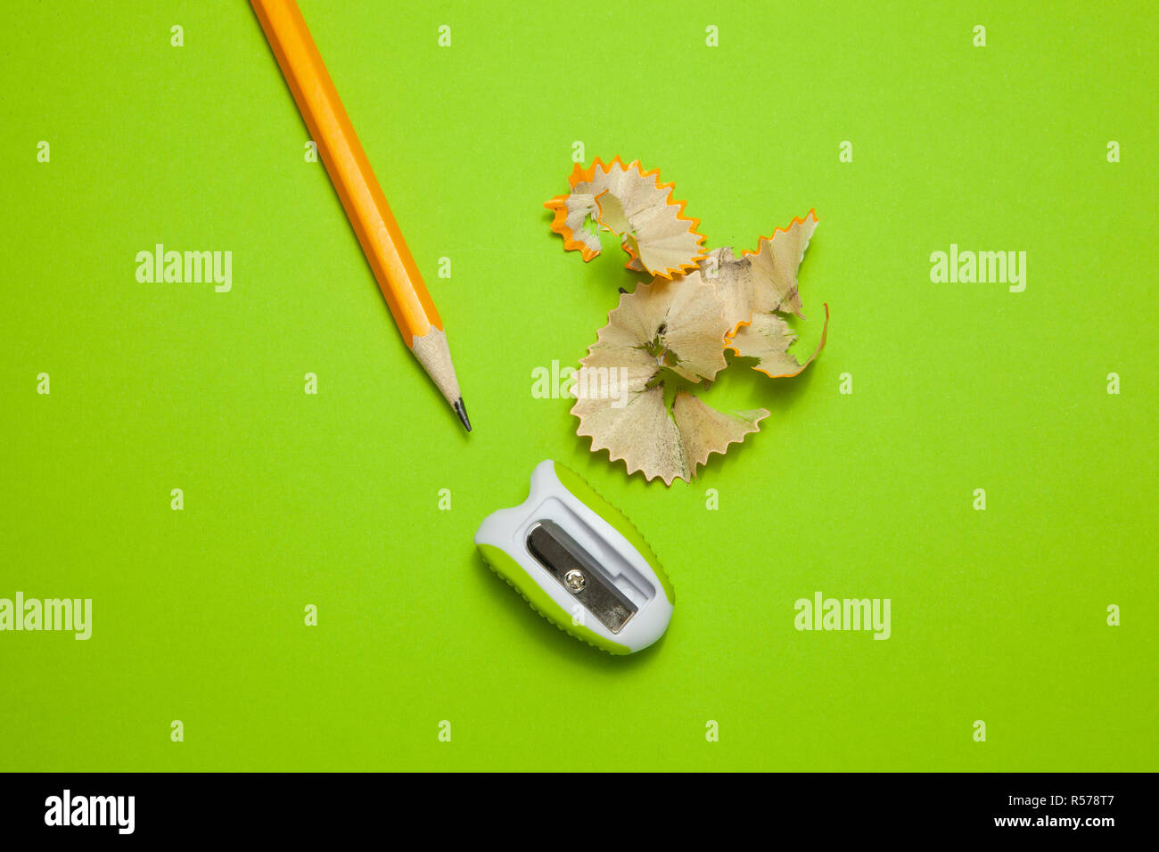 Sharpened pencil and sharpener on green background Stock Photo