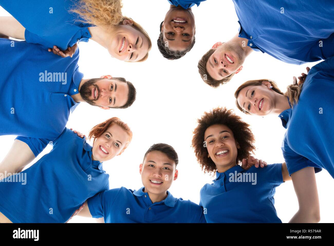 Happy Multiracial Janitors Forming Huddle Stock Photo