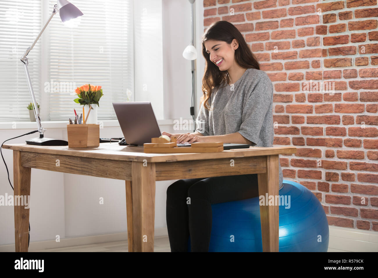 Female office using exercise ball hires stock photography and images