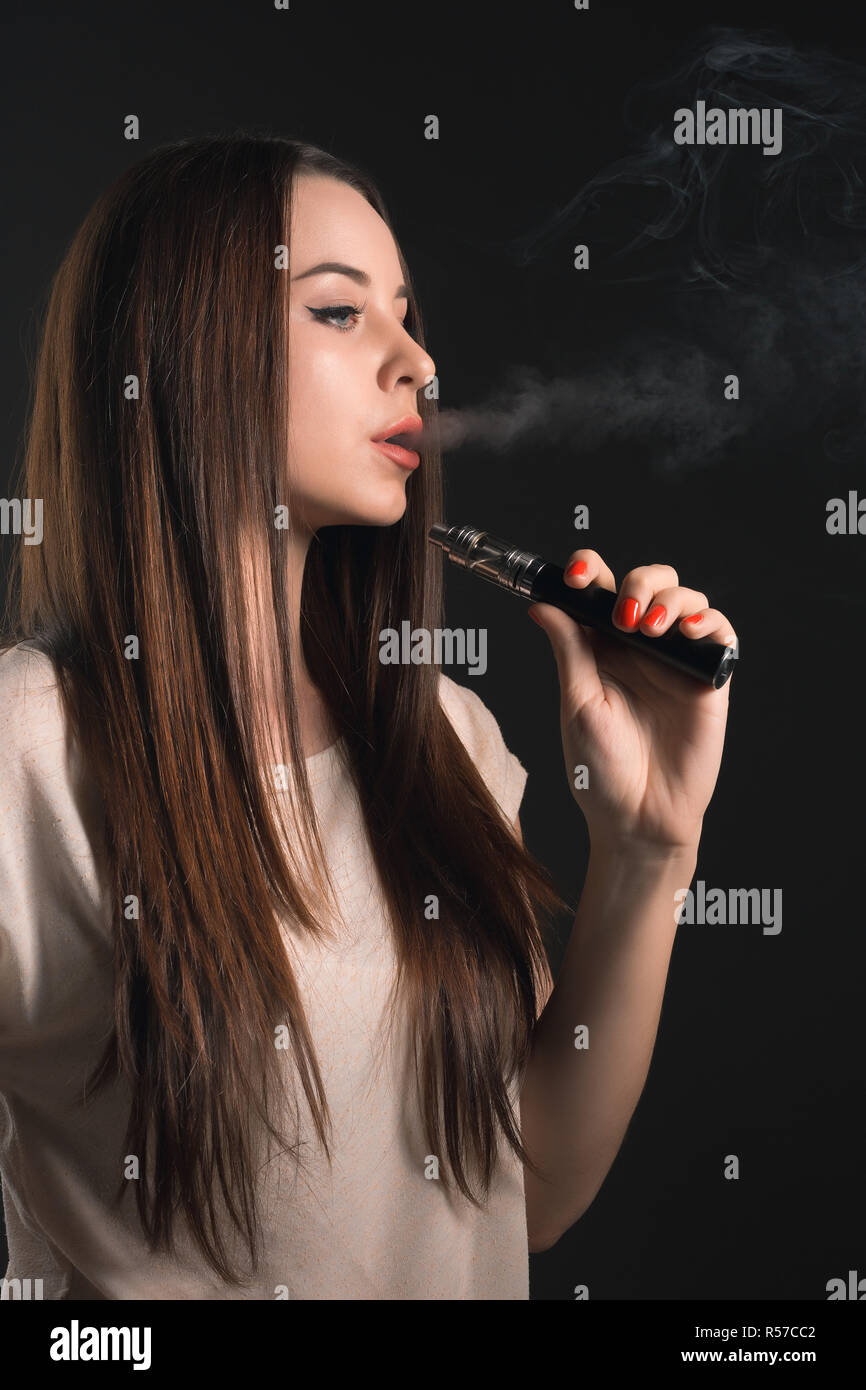 The face of vaping young woman at black studio Stock Photo Alamy