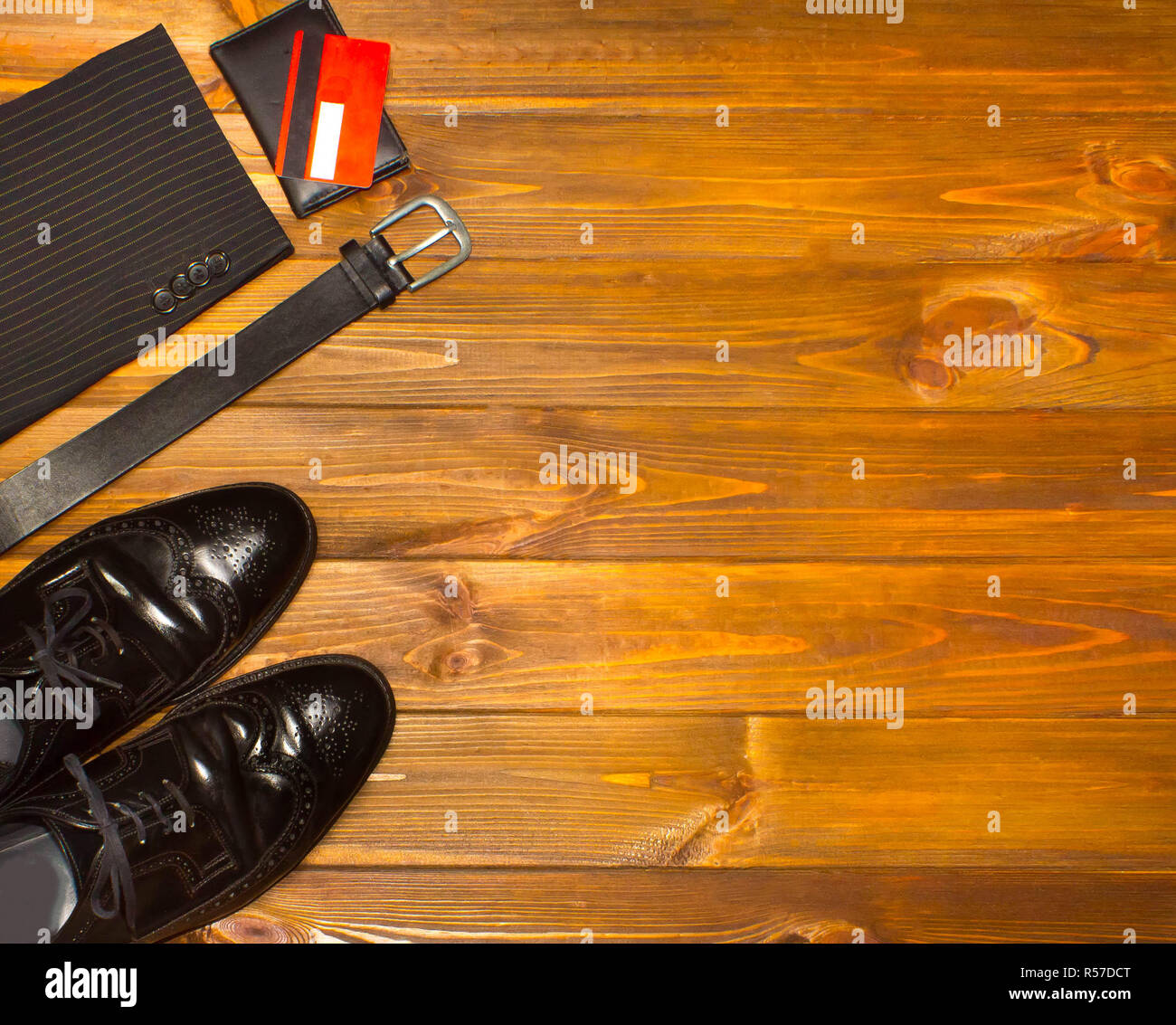 The elegant male set: men's shoes, leather belt, on the wooden background. Stock Photo