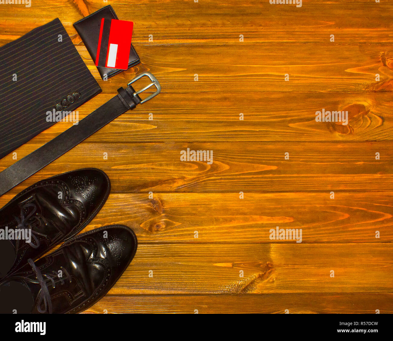 The elegant male set: men's shoes, leather belt, on the wooden background. Stock Photo
