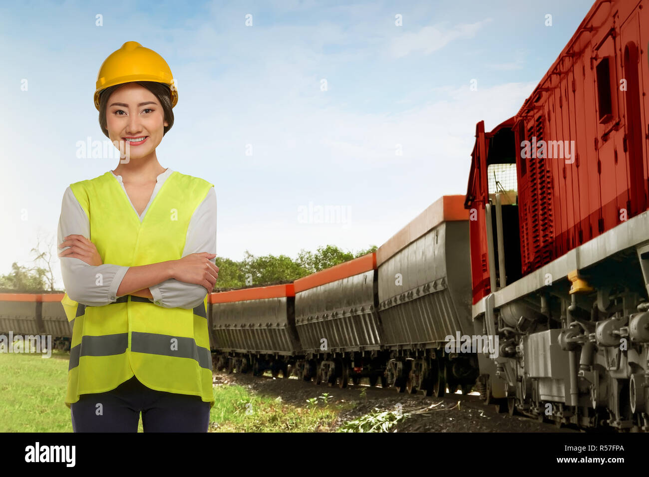 Beautiful asian railway employee woman standing beside freight train Stock Photo