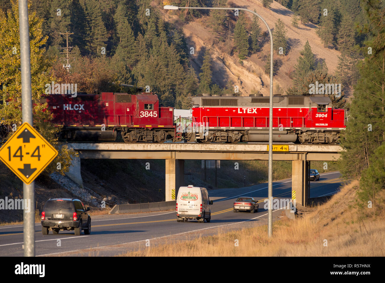 Locomotives crossing a railroad bridge in Kettle Falls, Washington. Stock Photo