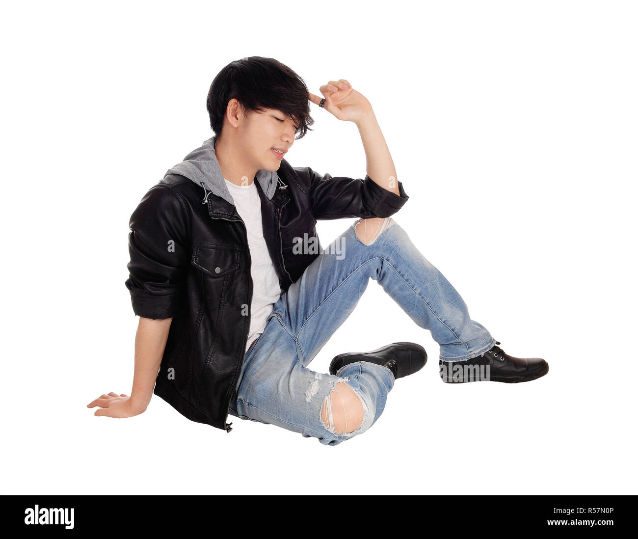 Young Asian man sitting on floor. Stock Photo