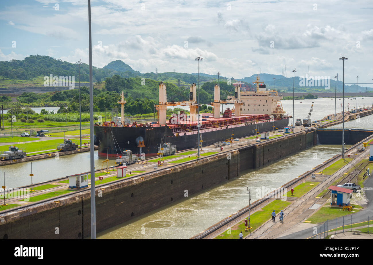 Large cargo ships pass through the Panama Canal locks.  This everyday event, provides income from both fees and tourism for the whole country. Stock Photo
