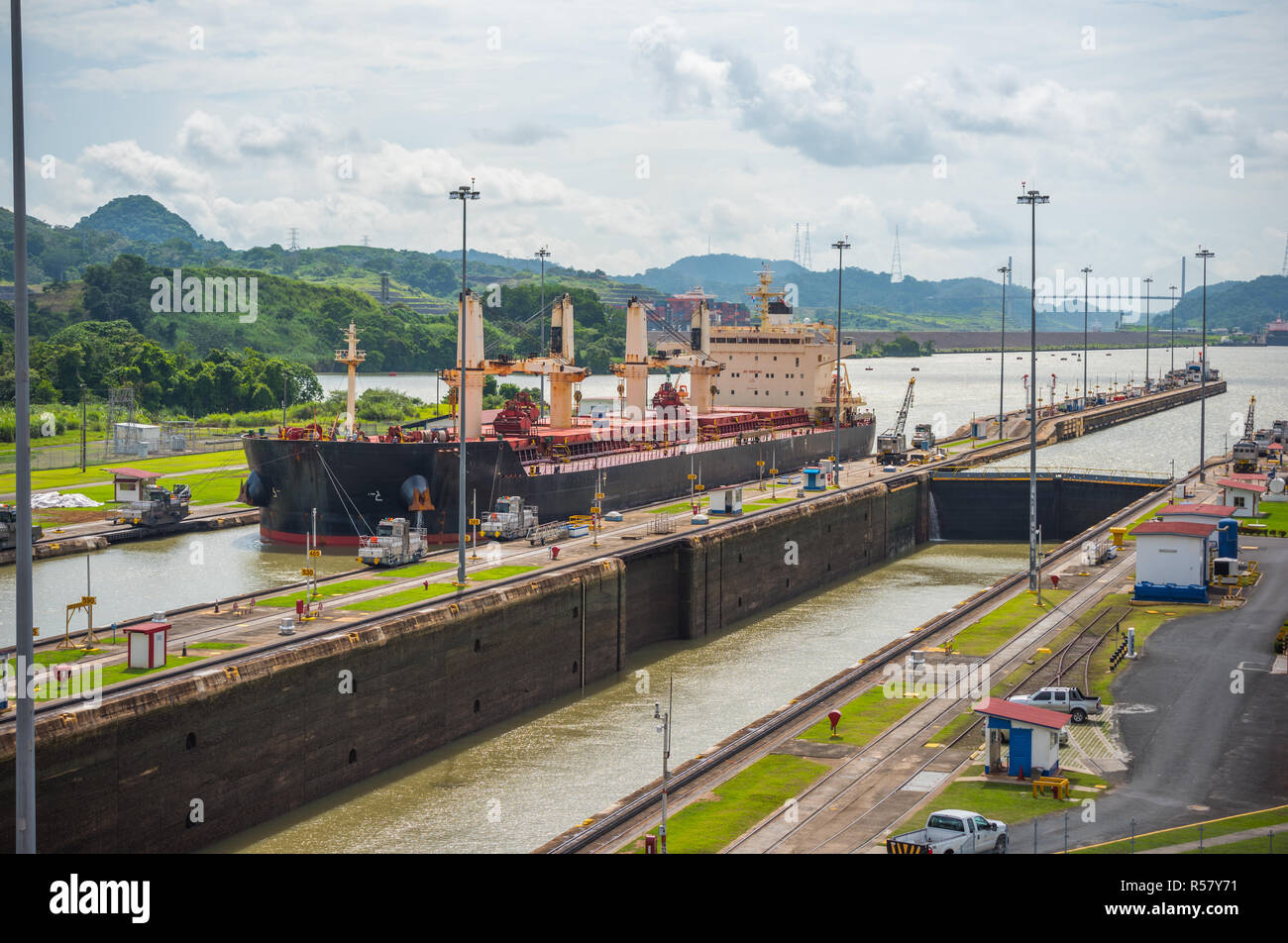 Large cargo ships pass through the Panama Canal locks.  This everyday event, provides income from both fees and tourism for the whole country. Stock Photo