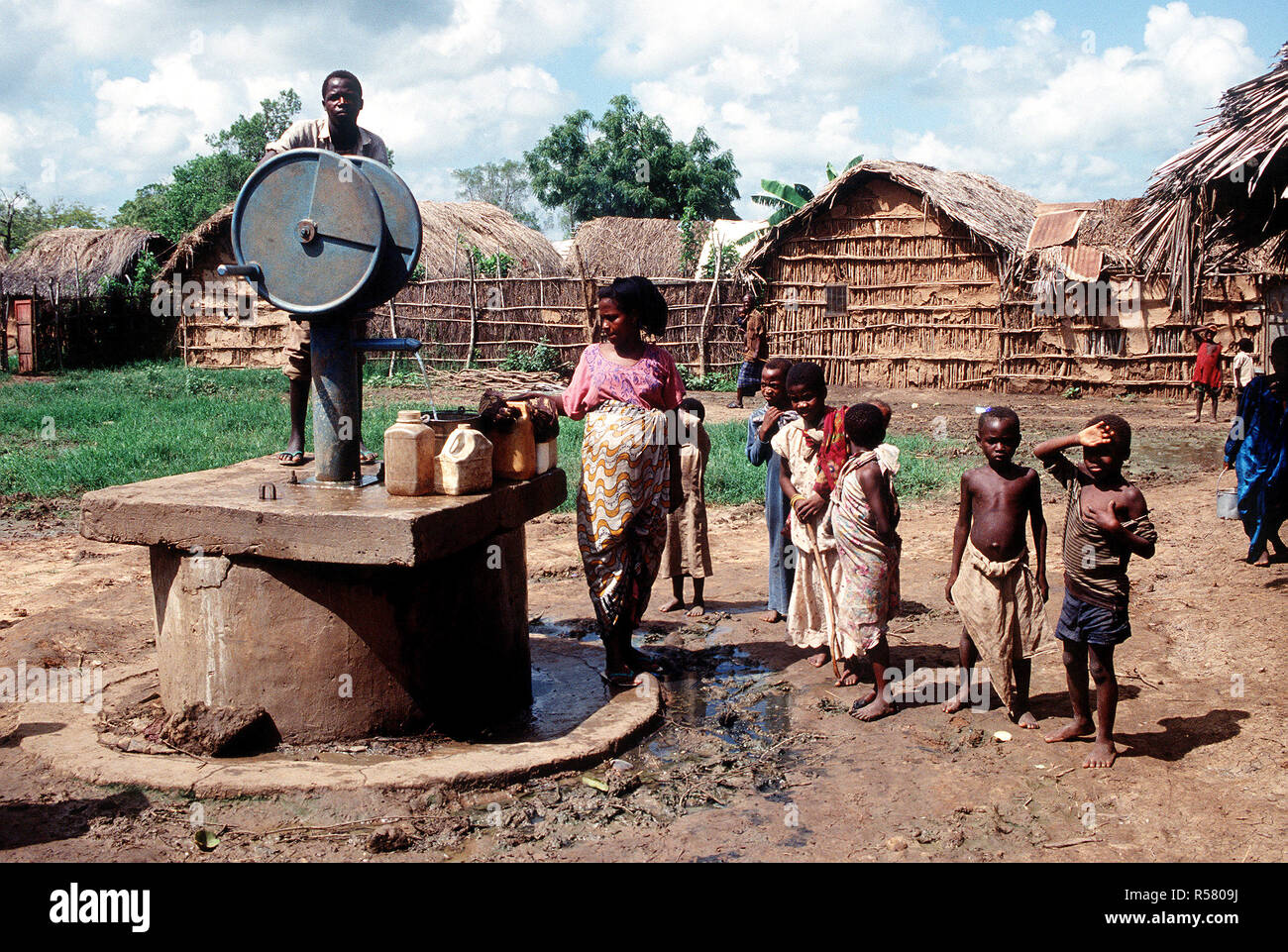 Local villagers use a water pump installed by a team of Belgian engineers who also dug a new well. Stock Photo