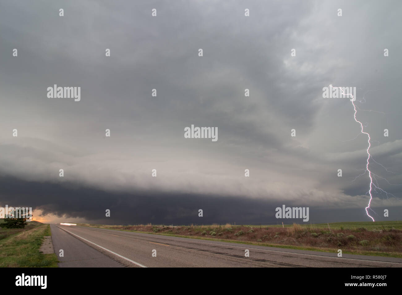 A lightning bolt arcs out of a supercell thunderstorm, striking the ...