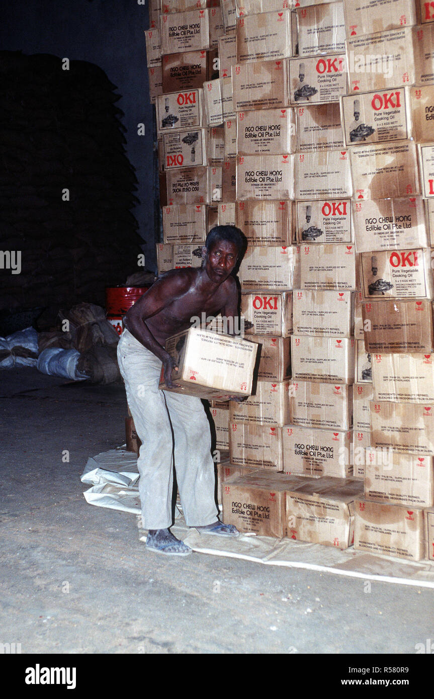 1993 - A Somali man works in a food storage warehouse in Kismayo. The supplies are deliverd to food distribution centers by a Belgian contingent that is in Somalia in support of Operation CONTINUE HOPE. Stock Photo