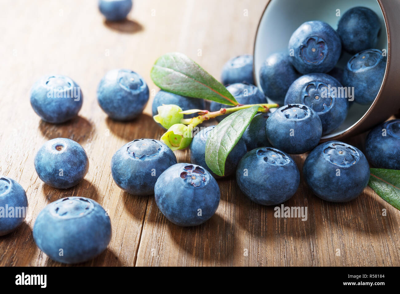Blueberries  closeup with green leaves on rustic  wooden table.Concept healthy eating Stock Photo