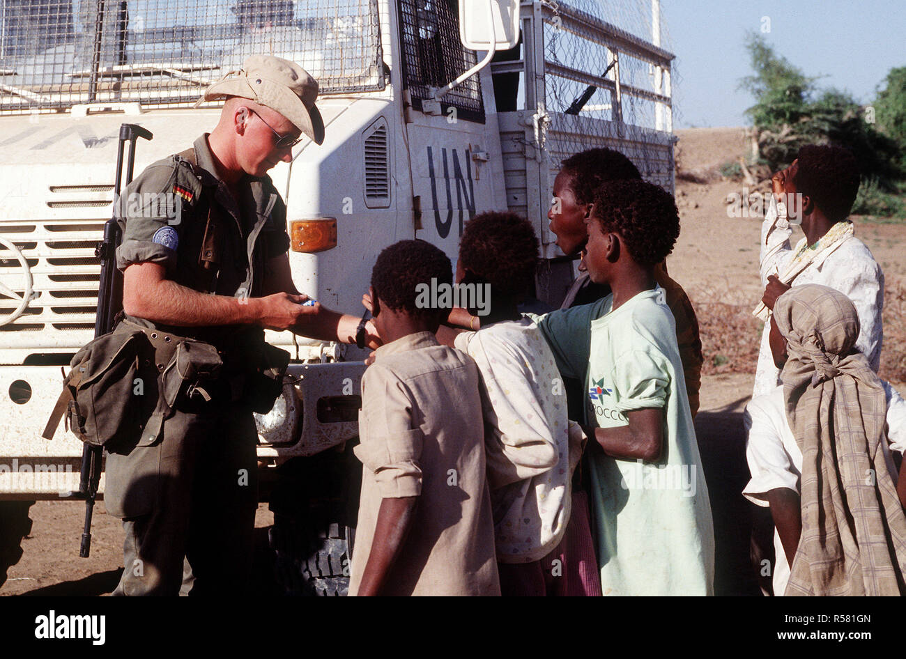 A German soldier hands out candy to Somali children in Belet Weyne  The soldier is part of the United Nations contingent supporting Operation CONTINUE HOPE Stock Photo