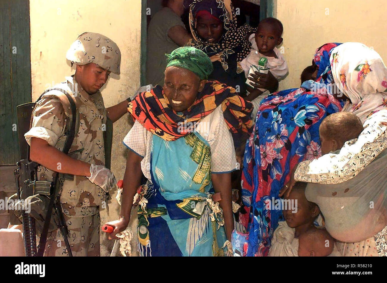 1993 - A US Marine helps a Somali woman on crutches from a clinic in Mogadishu, Somalia, where US Navy doctors (not shown) conducted a medical civic action program in the capital city. Stock Photo