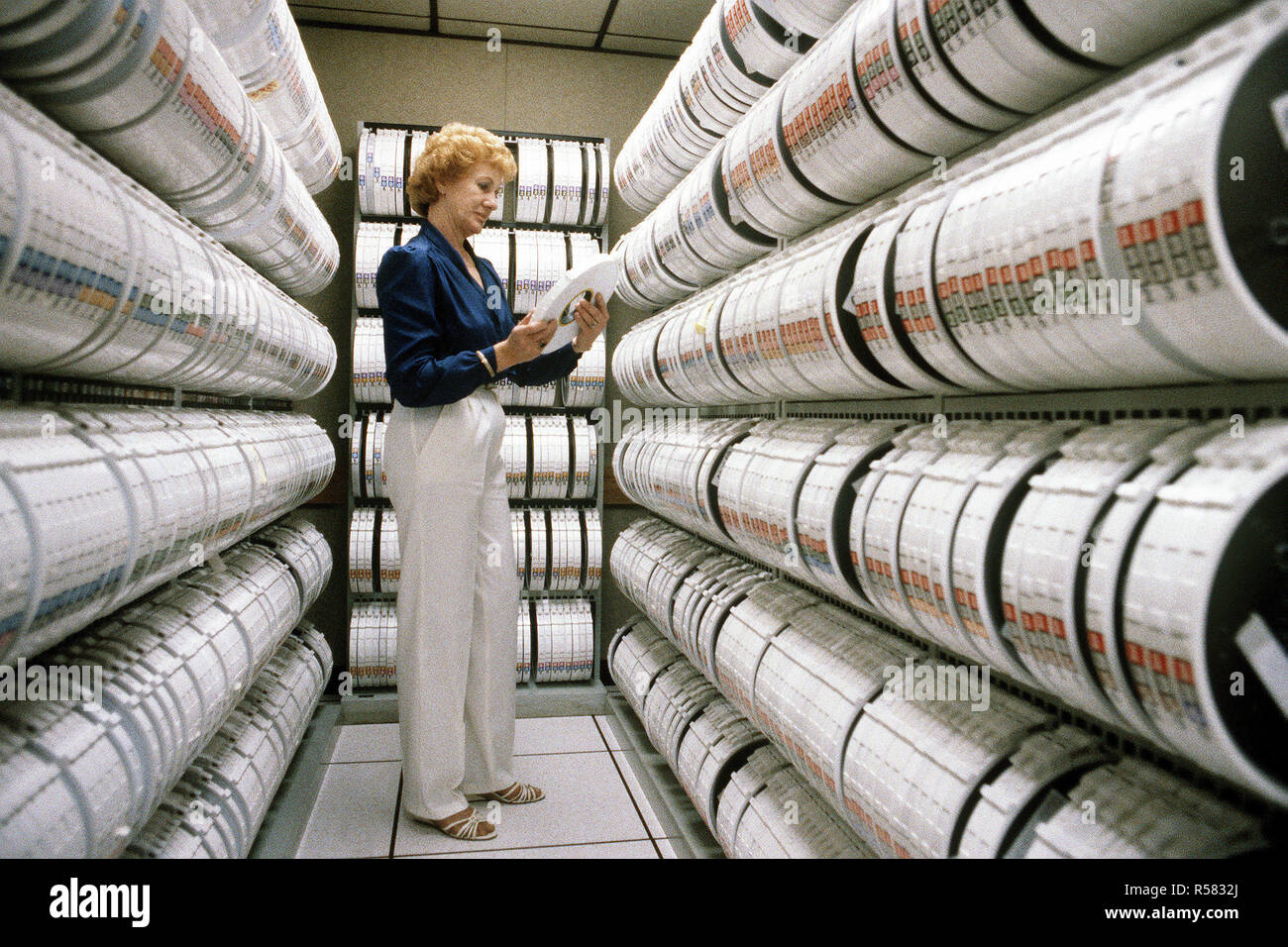 A civilian employee selects a computer tape at the Base Information