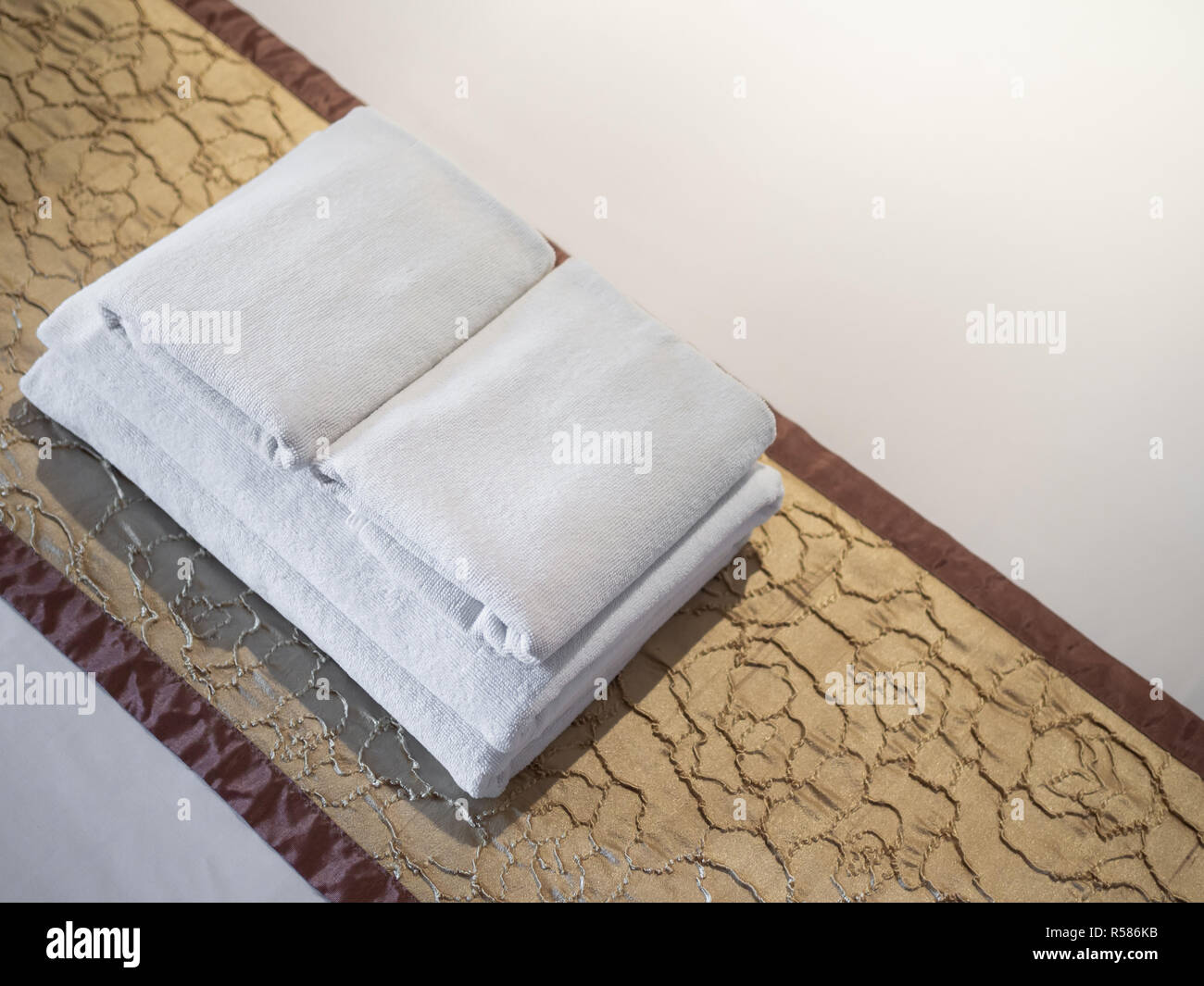 Clean white towels on bed in luxury room in hotel with copy space Stock