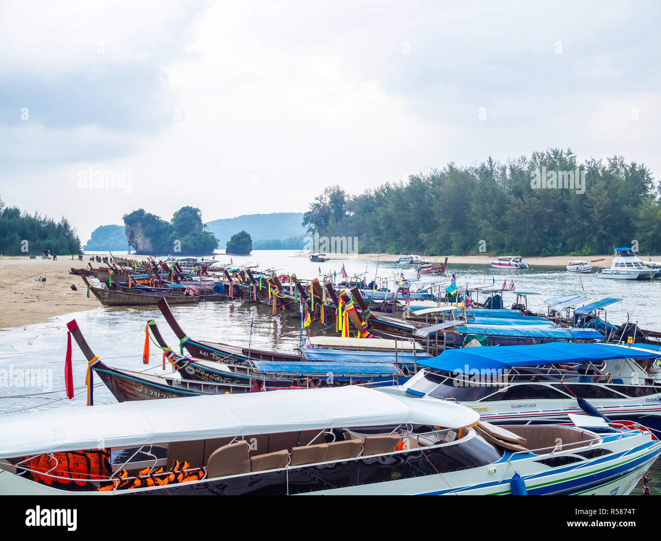KRABI, THAILAND - NOVEMBER 3, 2018 - Many traditional travel long-tail boats and luxury motor boats parking Ao Nang port with seascape background at K Stock Photo