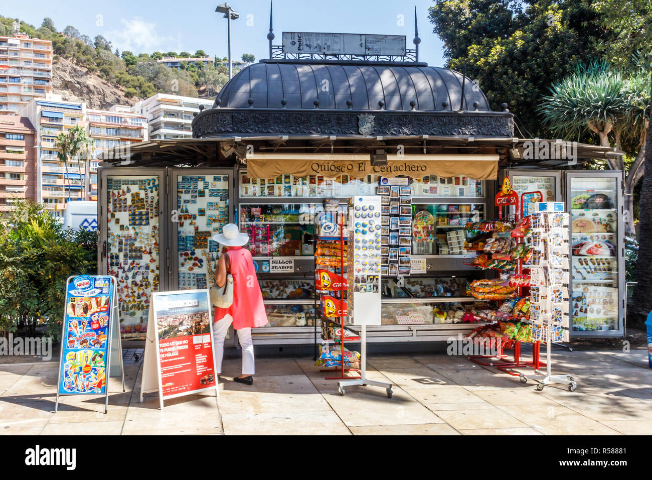 Malaga, Spain - 26th August 2015:  A  woman looks at postcards at a kiosk. Kiosks sell a variety of items, Stock Photo