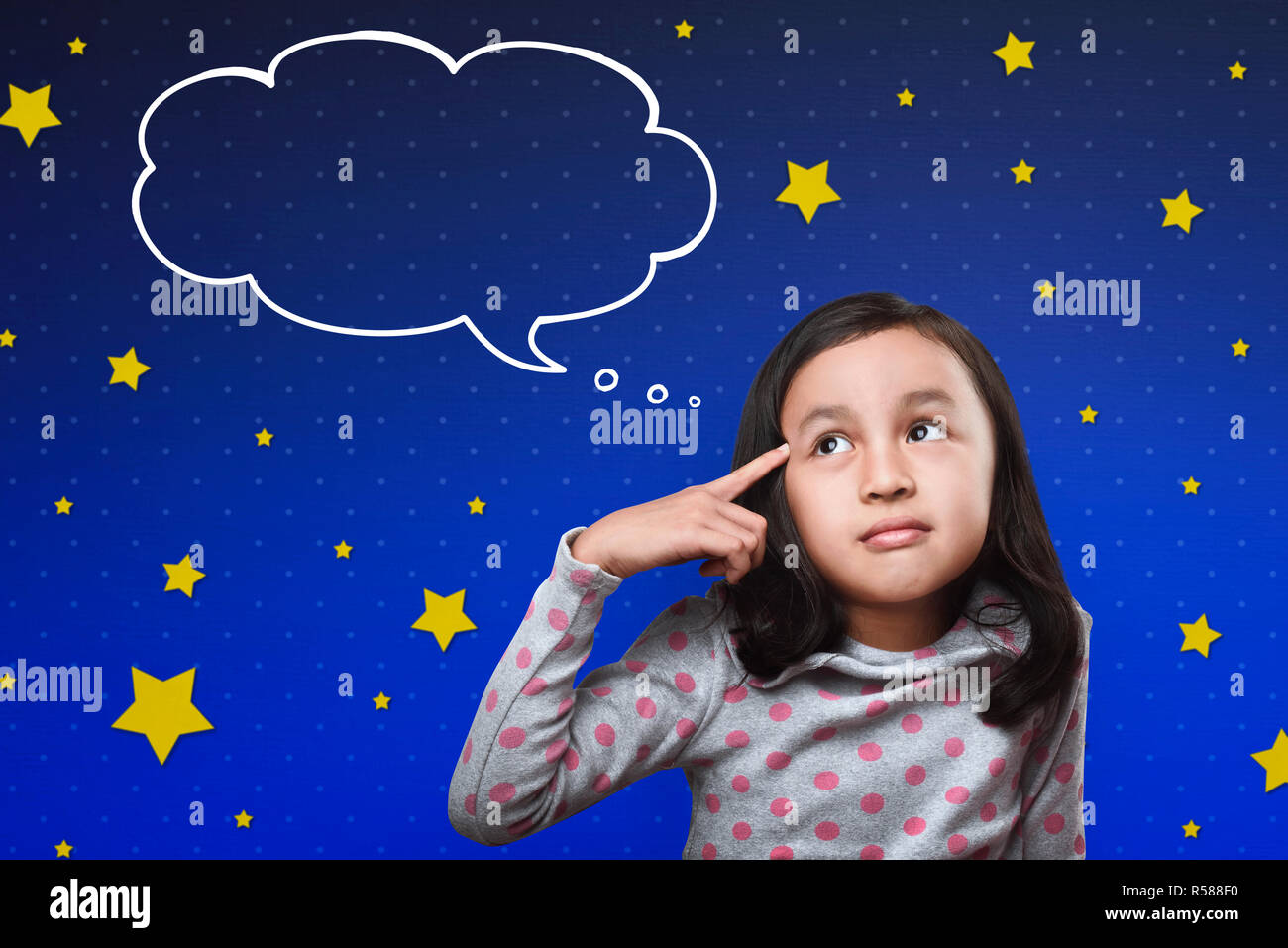 Cheerful asian child thinking with cloud space for text Stock Photo