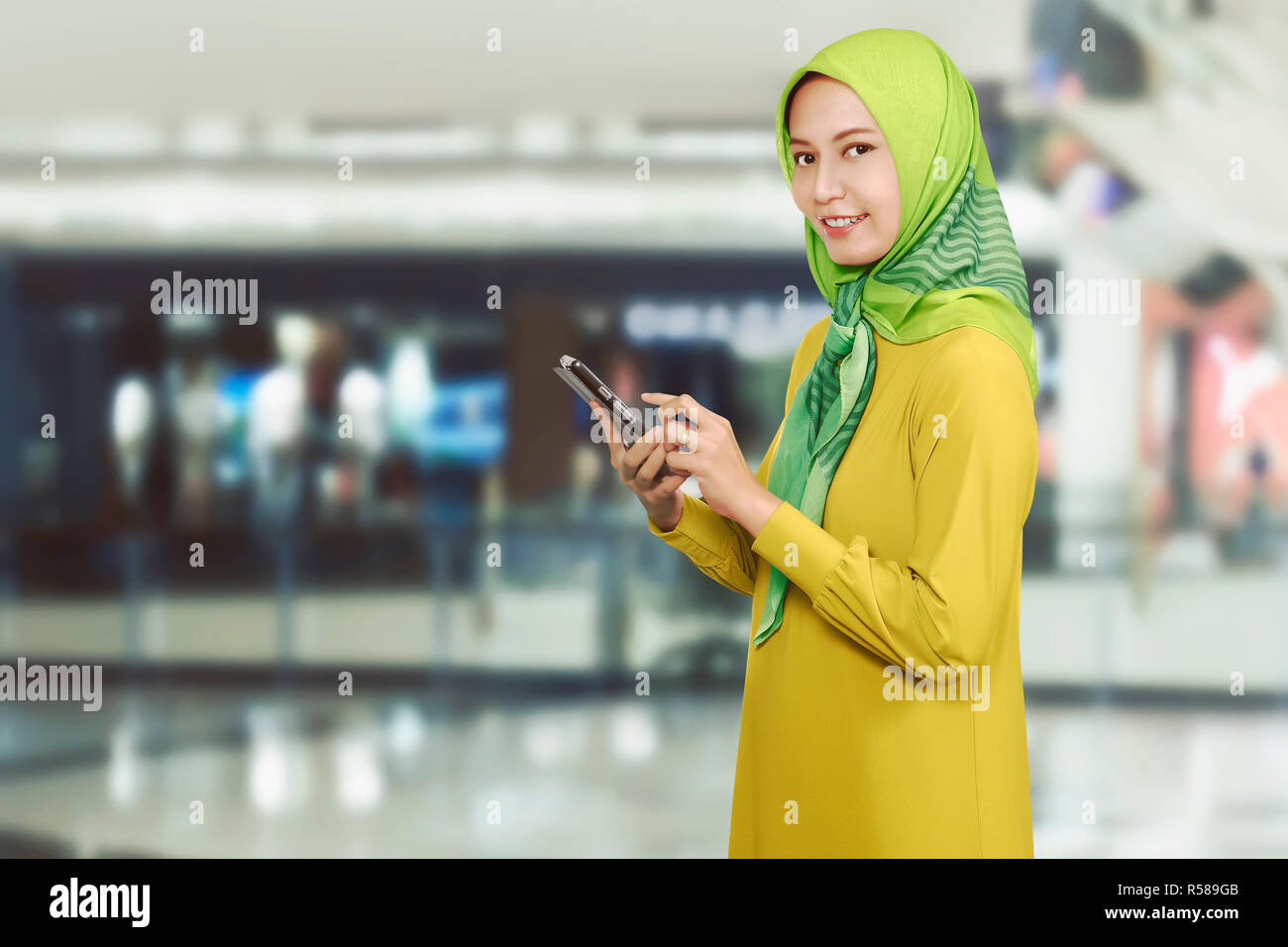 Pretty asian muslim female with mobile phone Stock Photo - Alamy