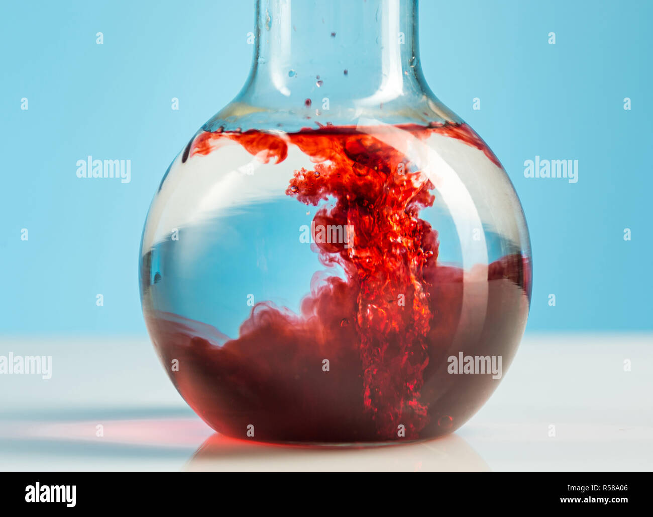 The laboratory glassware and red liquid inside on white Stock Photo