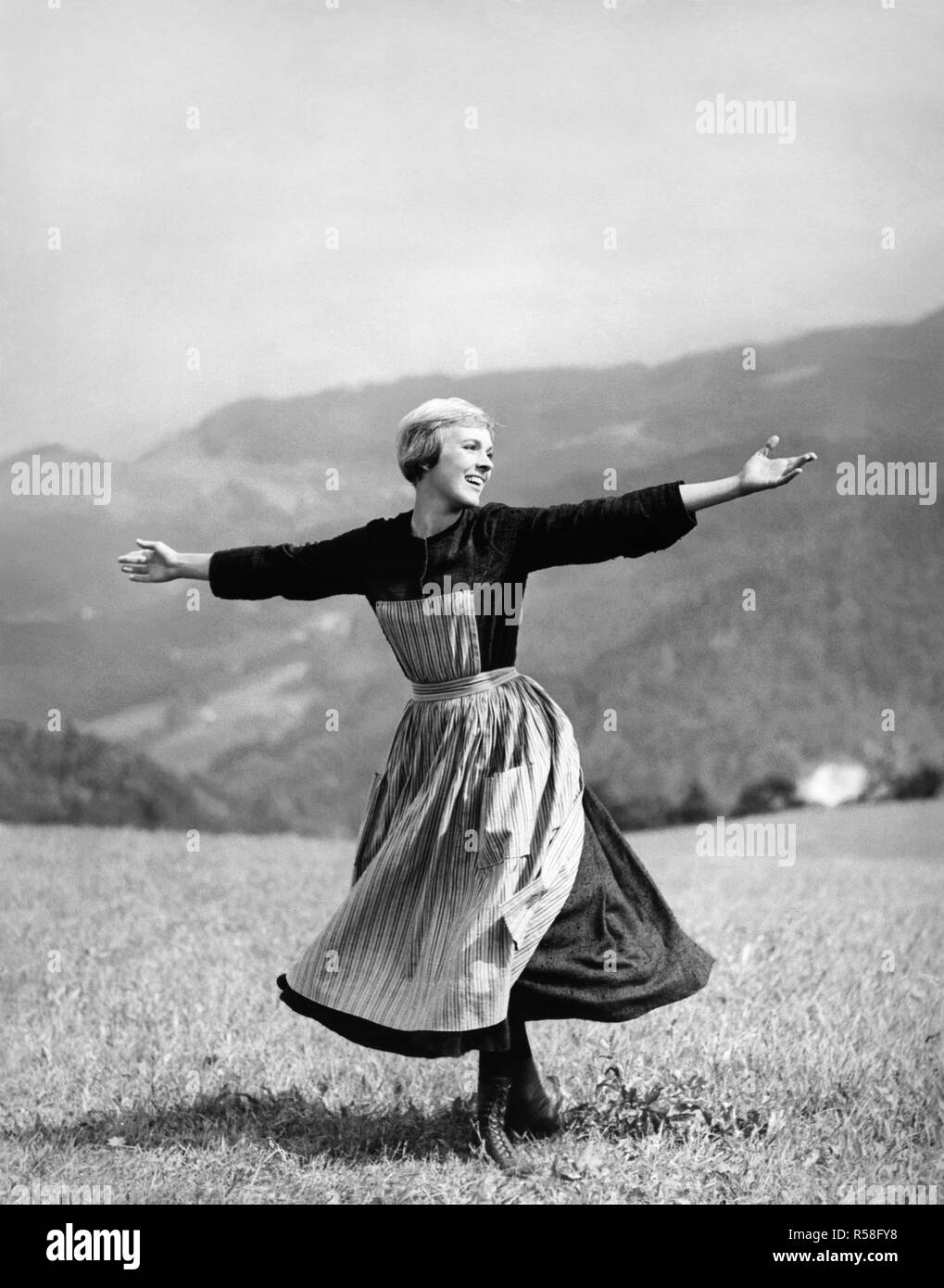 Julie Andrews twirling and singing on a mountaintop meadow in the 1965 Academy Award winning movie, The Sound of Music. Stock Photo