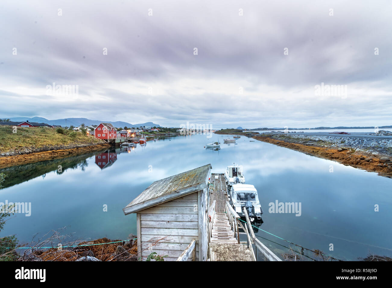 View of a small wooden dock and wooden houses next to the main Port of Bronnoysund in Norway. Stock Photo