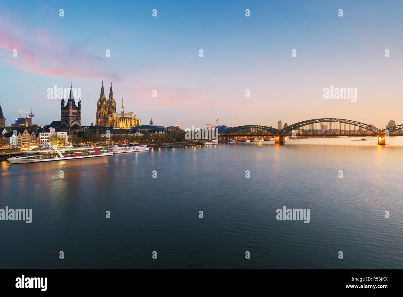 Image of Cologne with Cologne Cathedral with Rhine river and Hohenzollern  bridge during twilight blue hour in Germany. Stock Photo