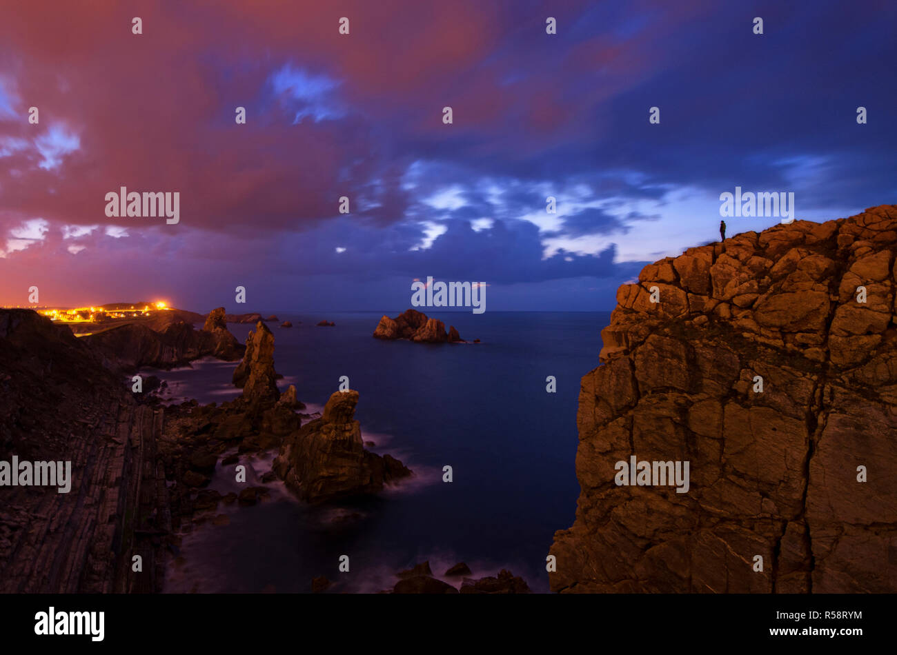 Light pollution and blue hour over the Atlantic coast, Costa Quebrada, Basque Country, Spain Stock Photo