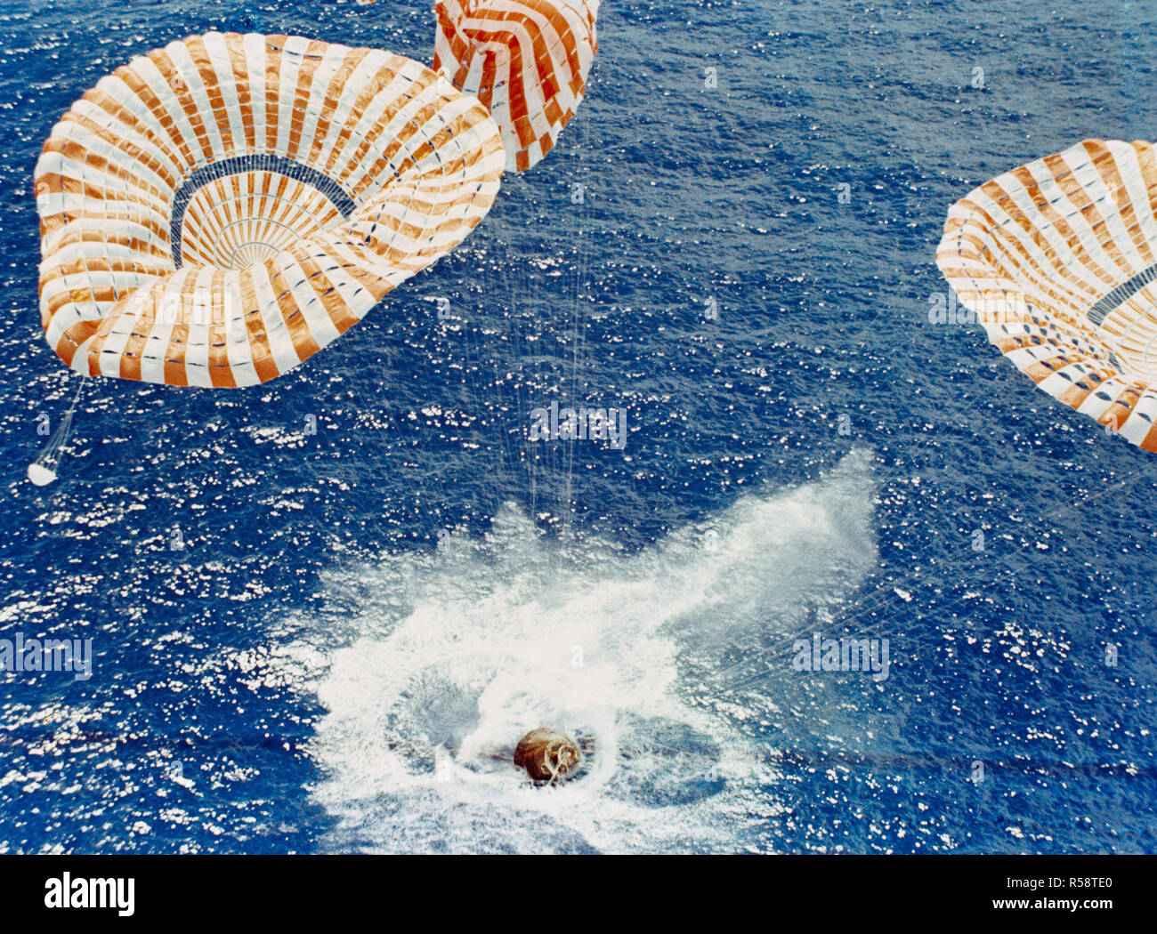 (7 Aug. 1971) --- The Apollo 15 Command Module (CM), with astronauts David R. Scott, commander; Alfred M. Worden, command module pilot; and James B. Irwin, lunar module pilot, aboard safely touches down in the mid-Pacific Ocean to conclude a highly successful lunar landing mission. Stock Photo