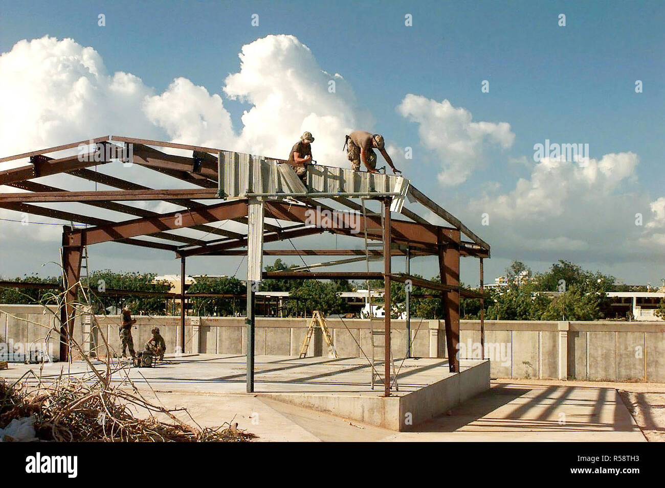 US Navy Seabees remove old metal sheathing from the frame of a building that they will rebuild into a kitchen and dining facility at the US Embassy compound in Mogadishu, Somalia.  This mission is in support of Operation Restore Hope. Stock Photo