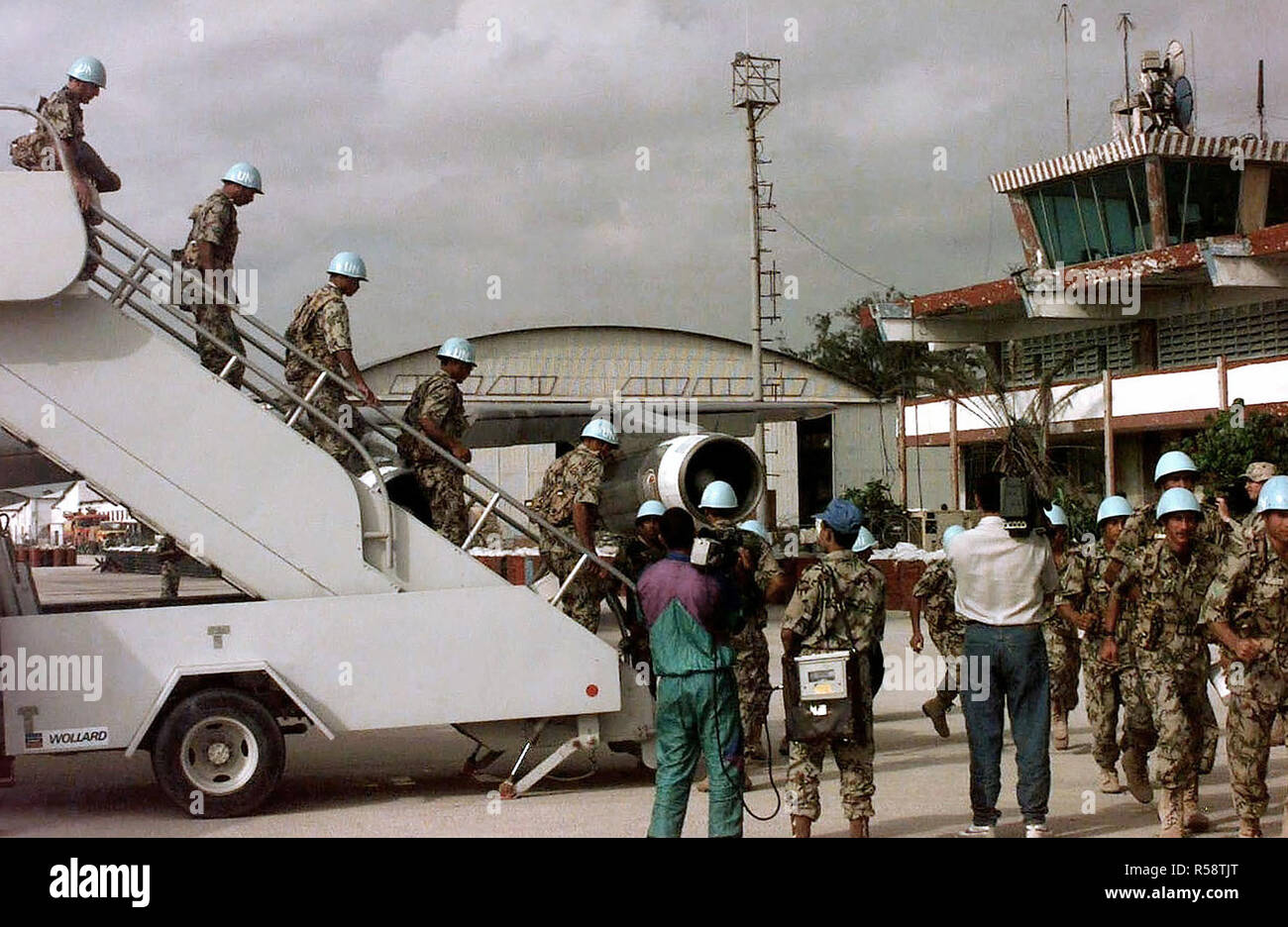 Egyptian troops, in light blue United Nations helmets, walk down a set of portable stairs at Mogadishu Airport.  The 3rd Battalion, Brigade Headquarters troops file off a 747 Egyptian airliner (not shown).  They are in the country to provide support for the United Nations Task Force that is in support of Operations Restore Hope in Somalia. Stock Photo