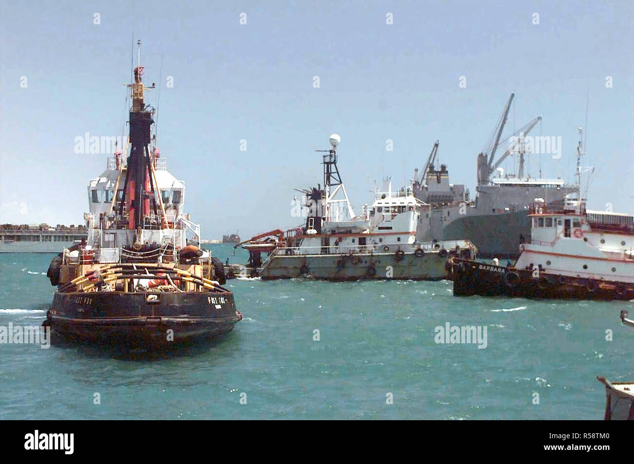 Tugboats jockey for position in Mogadishu Somalia's crowded harbor, where the arrival of military and relief supply ships have turned the once-empty port into a hive of activity.  The harbor has come under the aegis of Joint Task Force Somalia, which is conducting Operation Restore Hope. Stock Photo