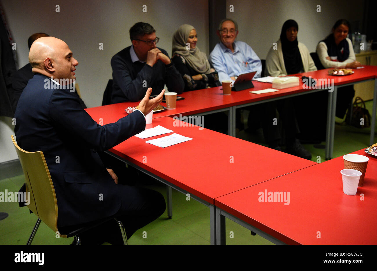Home Secretary Sajid Javid (left) speaks during a round table discussion on the Prevent anti-terror scheme, at the Chrisp Street Ideas Store in Poplar, London. Stock Photo