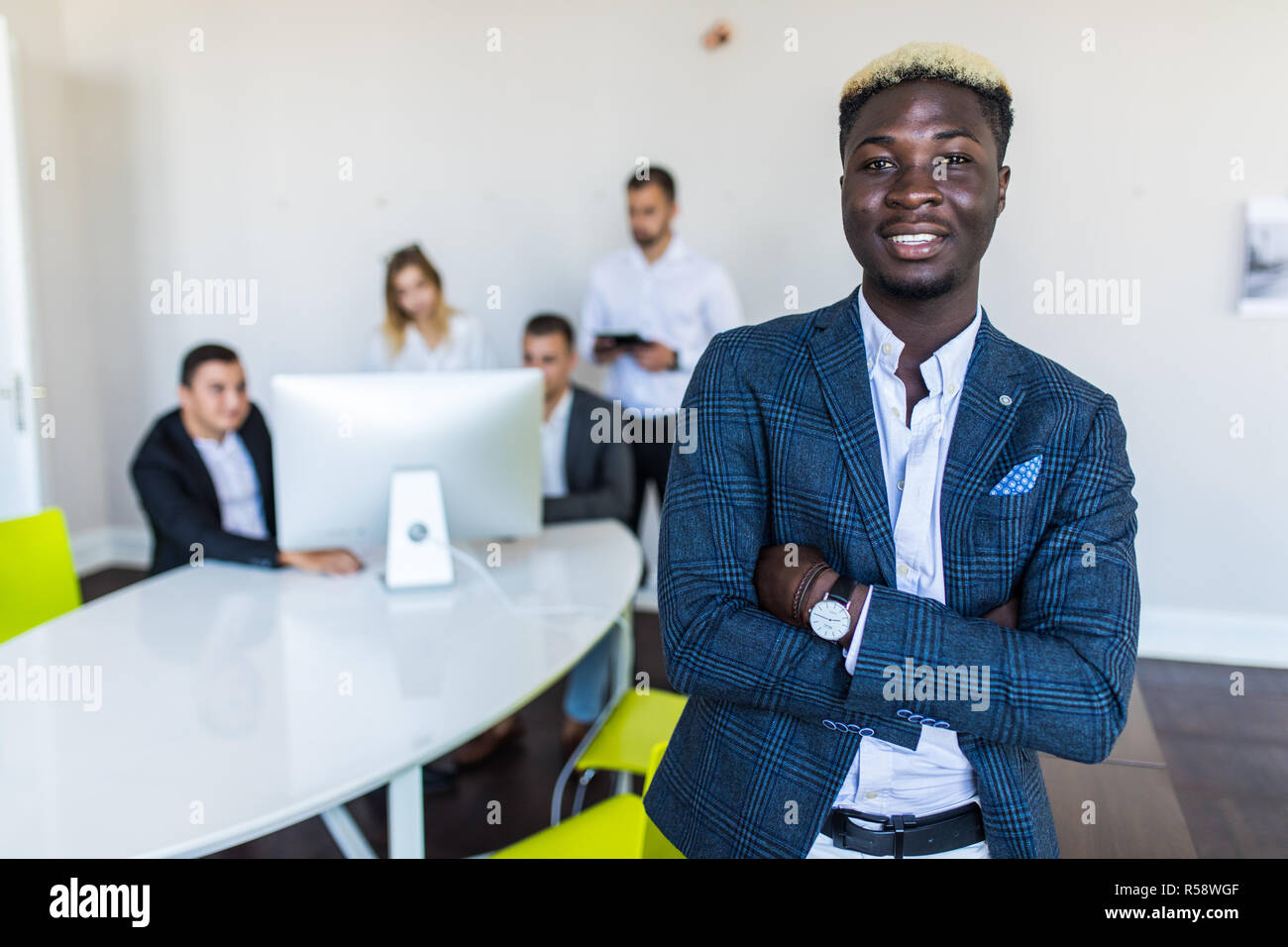 Young African-American Business leader standing inf front of business team smiling Stock Photo