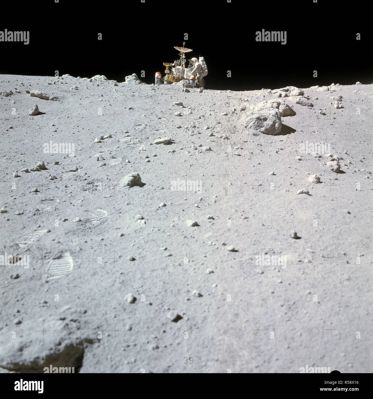 (23 April 1972) --- Astronaut Charles M. Duke Jr. works at the front of the Lunar Roving Vehicle (LRV) parked in this rock field at a North Ray Crater geological site during the mission's third extravehicular activity (EVA) on April 23, 1972. Stock Photo