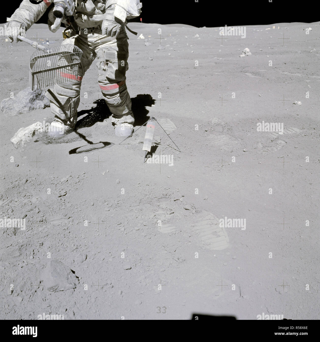 (23 April 1972) --- Astronaut John W. Young collects samples at the North Ray Crater geological site during the mission's third and final Apollo 16 extravehicular activity (EVA). He has a rake in his hand, and the gnomon is near his foot. Stock Photo