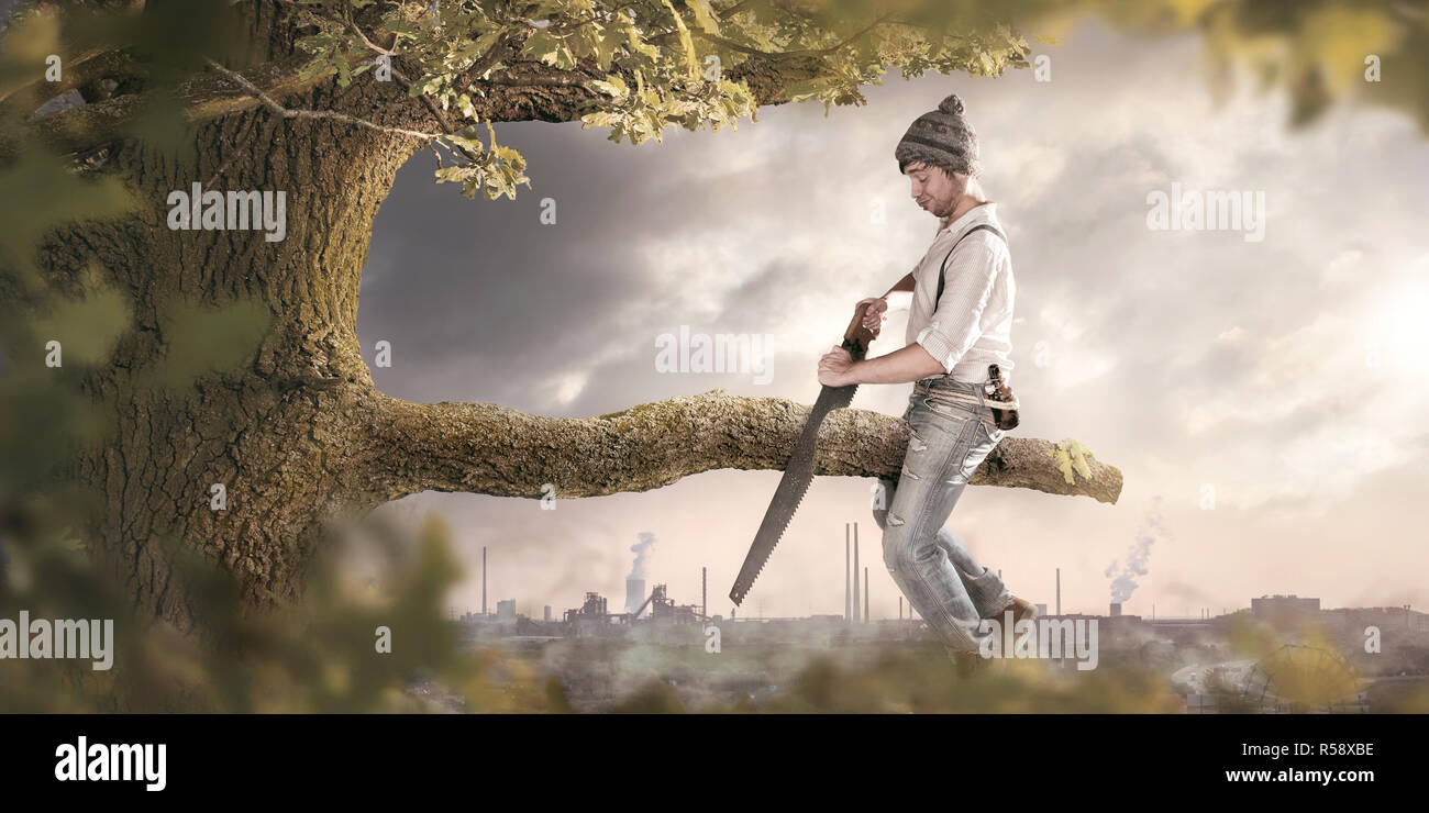A man is sawing off the branch he is sitting on Stock Photo