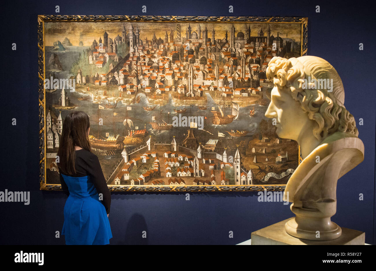A visitor views 'View of Constantinople', from the Italian School, dated circa 1600 and valued at £100,000 to £150,000, seen alongside a bust of Alexander the Great, dated to the late 18th century and valued at £15,000 to £25,000, on show at Christie's saleroom in central London ahead of the auction house's forthcoming Classic Week sales. Stock Photo