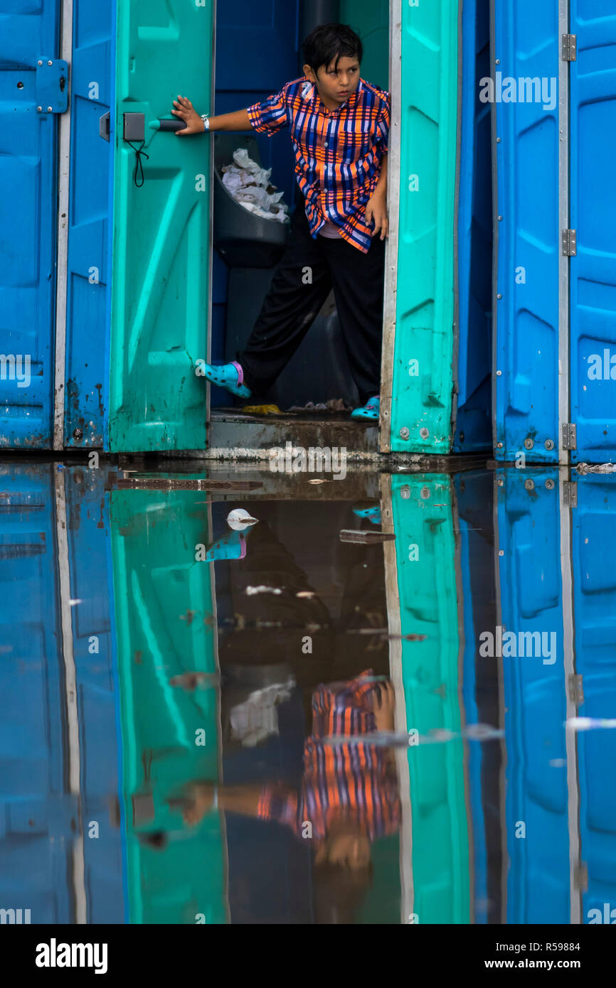 Tijuana, Mexico. 29th Nov, 2018. A child comes from a mobile toilet cabin. More than 6000 Central American migrants on the US border move to larger accommodation. The previous migrant accommodation in a sports facility was only designed for 3000 people and was overcrowded. Credit: Alejandro Gutiérrez Mora/dpa/Alamy Live News Stock Photo