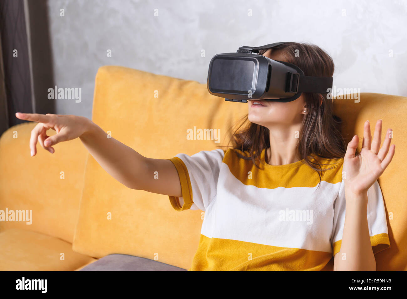 Attractive Long Haired Girl In Pullover Gesturing While Testing Vr Device She Sitting On The