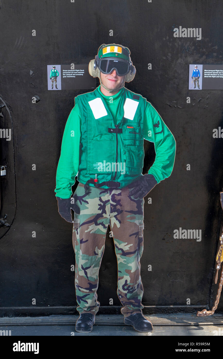 Green-jerseyed Flight Deck person (run and maintain the catapult & arresting gear machine) USS Midway Museum, San Diego, California, United States. Stock Photo