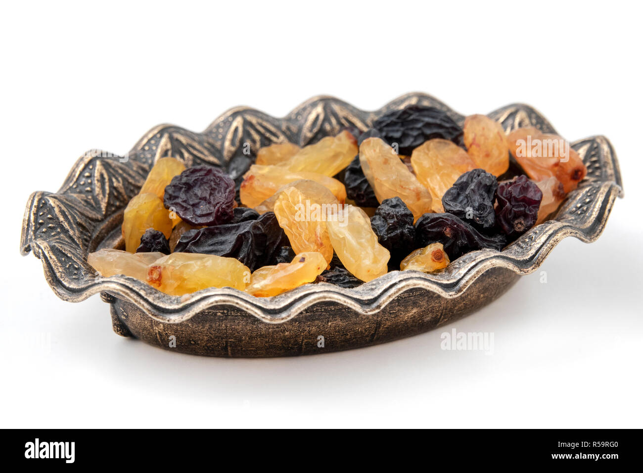 Black and yellow raisins on a white background Stock Photo