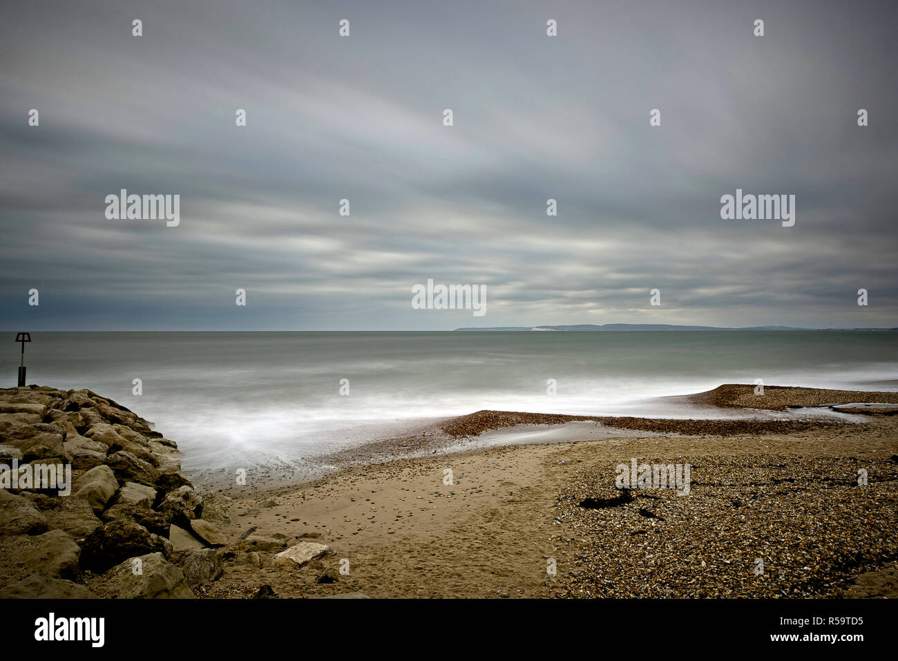 A stormy day with rough sea and fast moving clouds captured with a long exposure on Bournemouth's coastline. Stock Photo