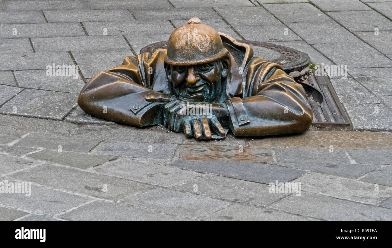 Bronze statue of a street worker emerging from a manhole in the old city of Bratislava, capital of Slovakia. Stock Photo