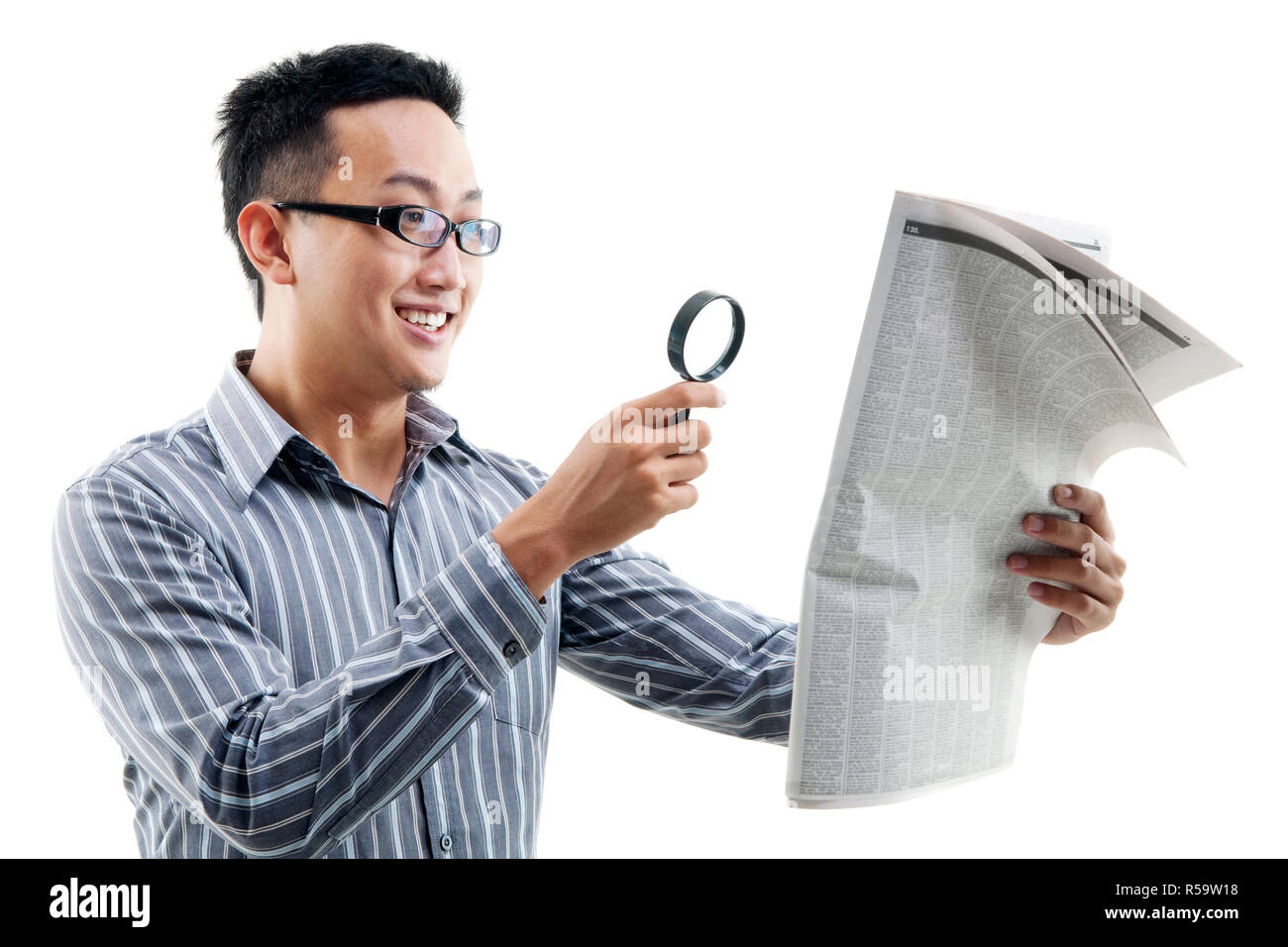 Asian man reading newspaper with magnifier Stock Photo