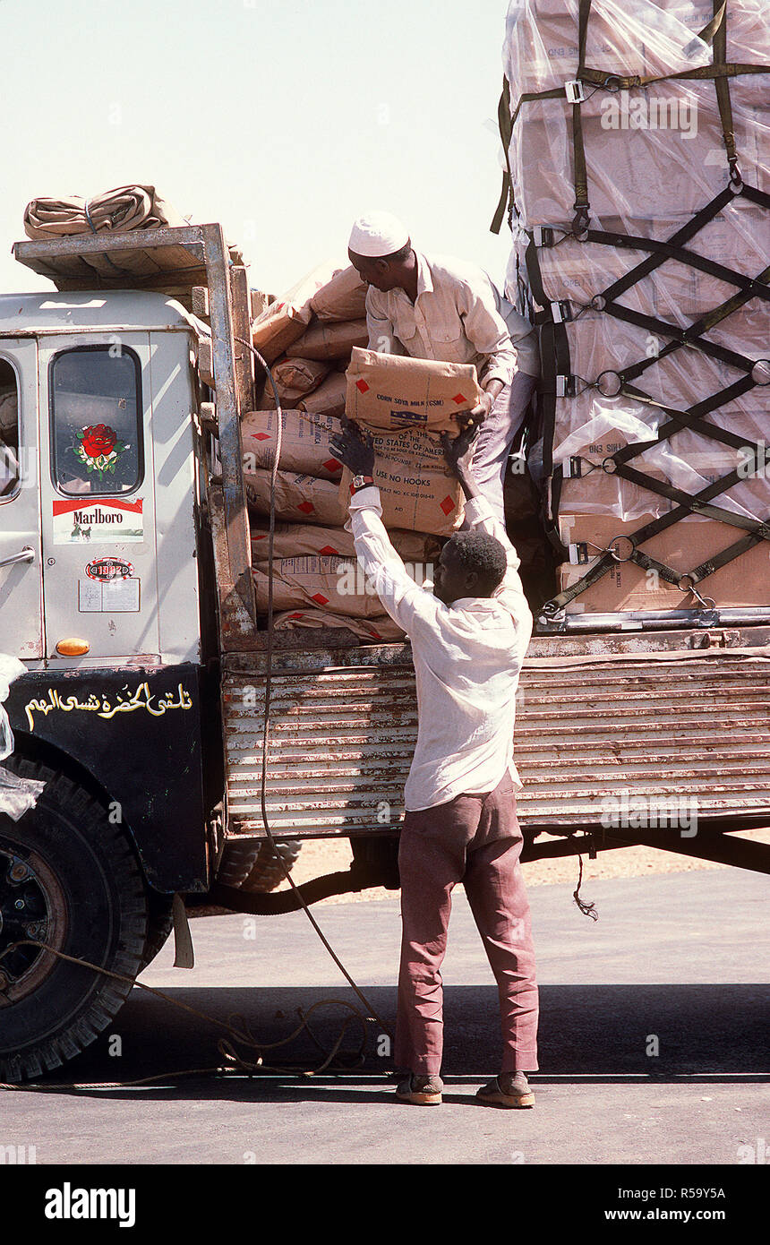 1985 - Two Sudanese workers load a truck with food and supplies that were flown into the airport aboard a 6th Military Airlift Squadron aircraft during Ethiopian relief operations.  The supplies will be moved to a distribution center and given to the needy. Stock Photo