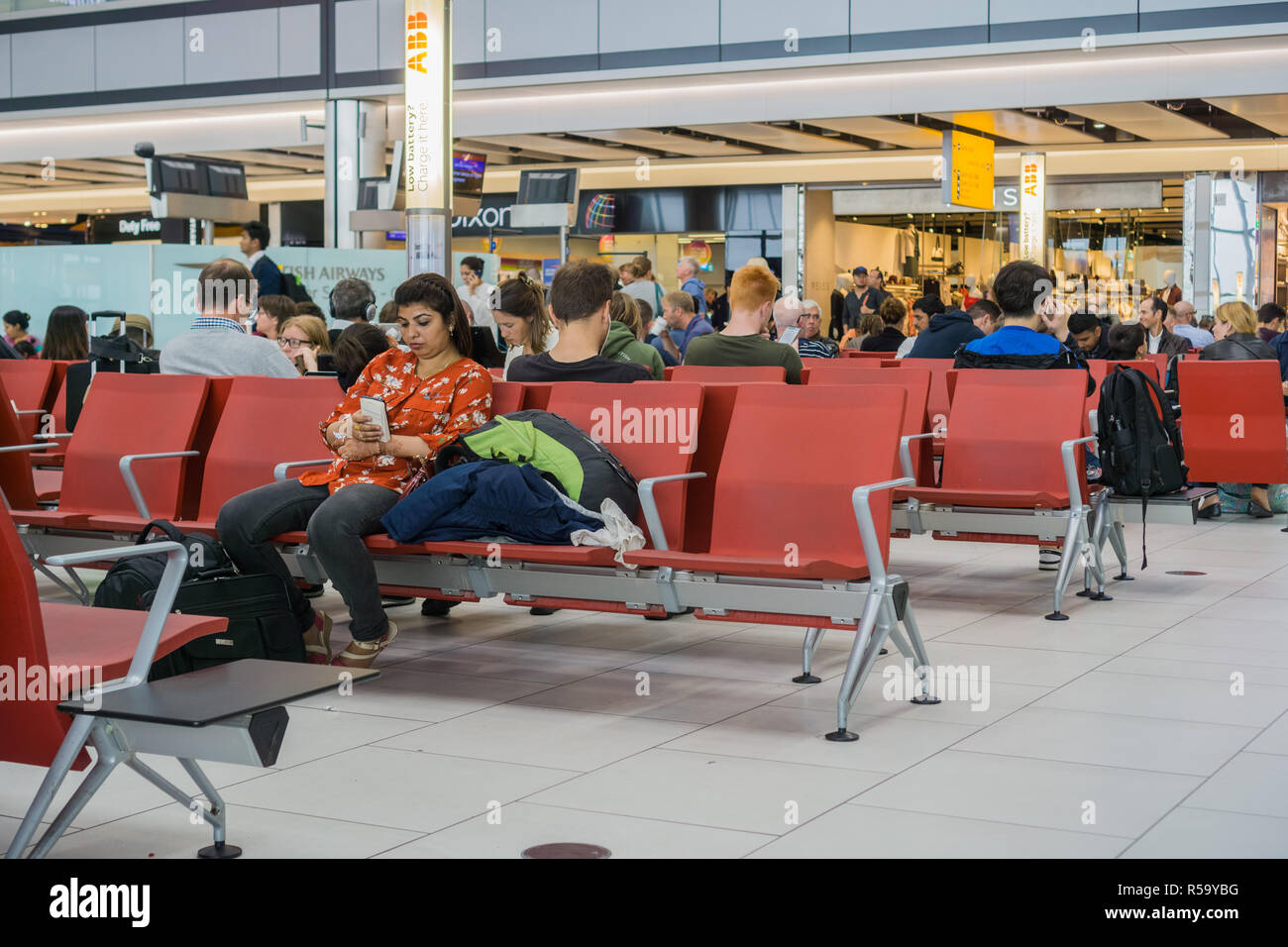 September 10, 2017 London/UK - People sitting on the chairs in one of the waiting areas at Heathrow airport Stock Photo
