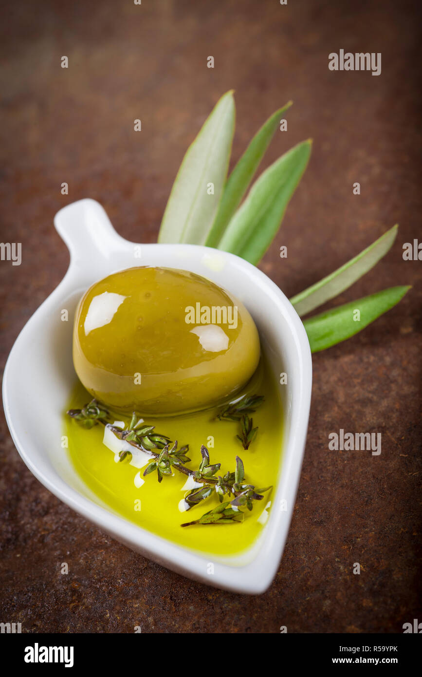 Extra virgin olive oil and green olives Stock Photo - Alamy