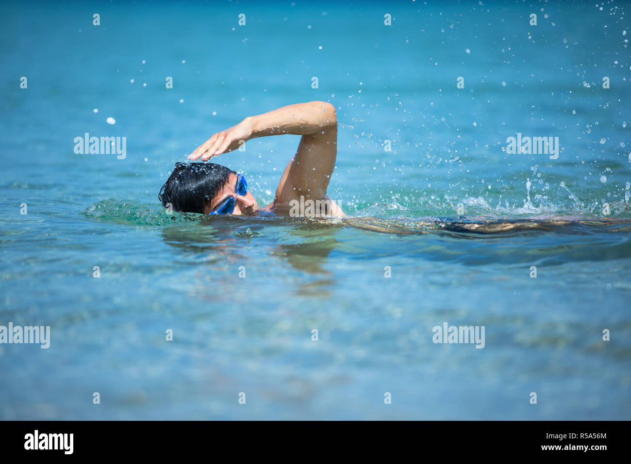 Young man swimming the front crawl in the sea (swimmer, triathlon Stock