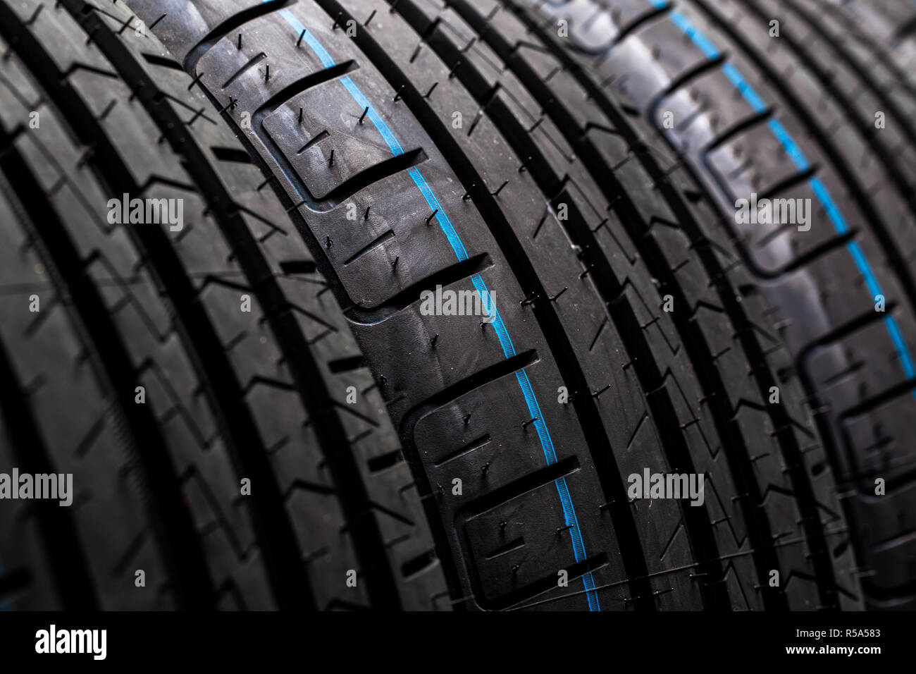 Stack of brand new high performance car tires on clean highkey white